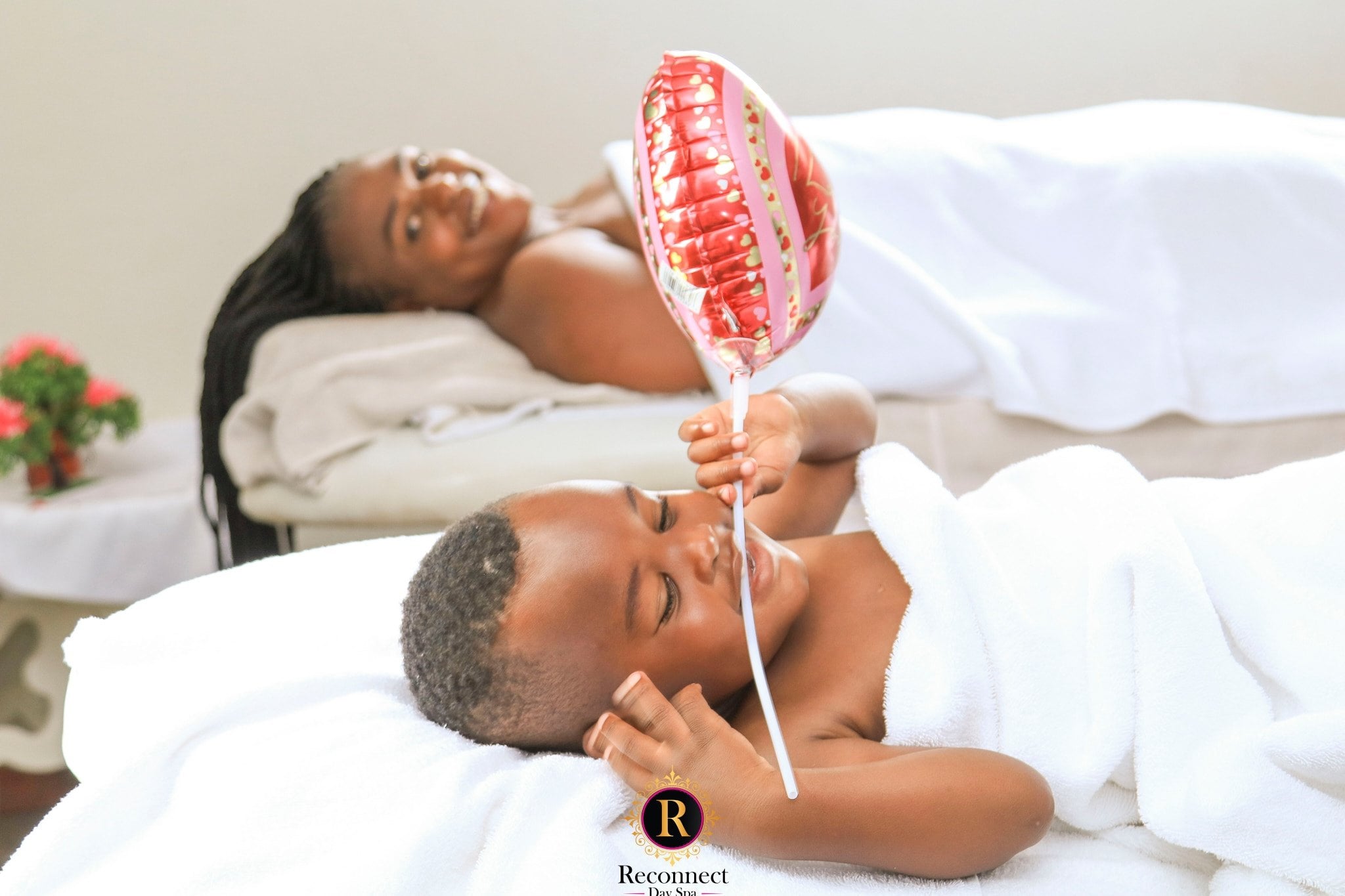 Child relaxing on a spa bed with a red balloon – Kids & Teens Full Body Massage, Reconnect Day Spa