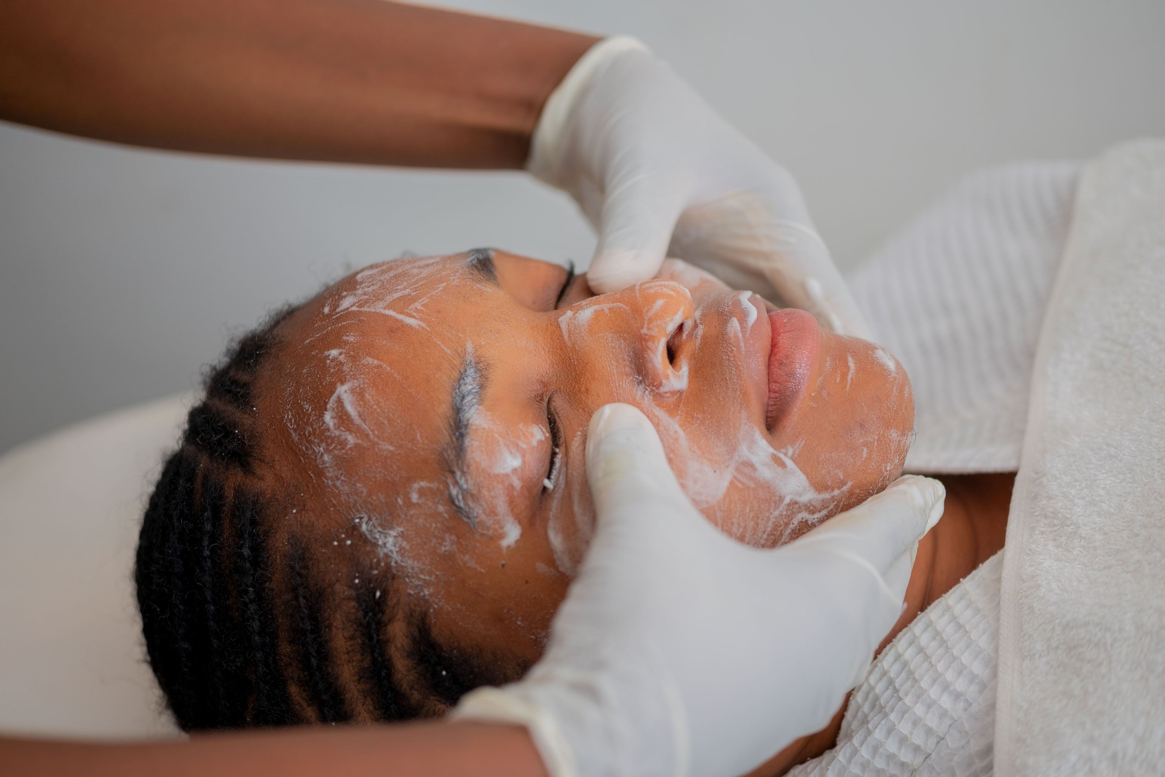 Therapist brushing a treatment mask onto a client's face – Appetizer Glow Facial, Reconnect Day Spa