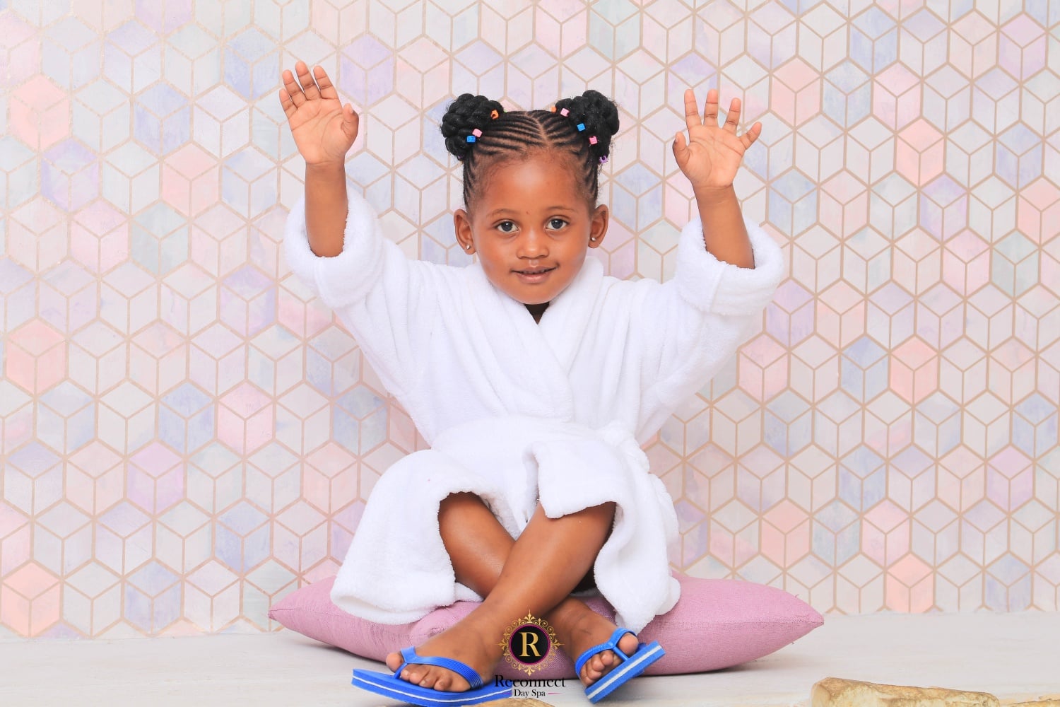 Little girl in a white spa robe cheering with her arms in the air – Kids & Teens Express Manicure with Nail Polish, Reconnect Day Spa
