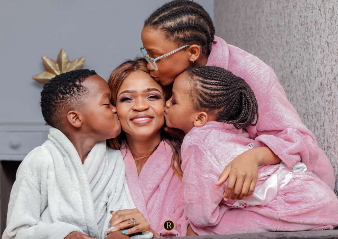 Mom hugging her children in pink spa robes – Mom & 2 Kids Spa Special, Reconnect Day Spa